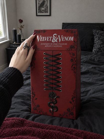 Velvet & Venom goth advent calendar on a bed, closed